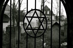 Iron gate with a Jewish star on it leading into an old cemetery