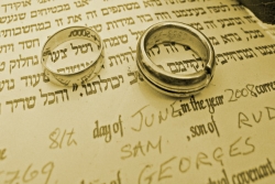 Ketubah (wedding contract) with two wedding rings on top of it