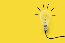 Bright lightbulb against a yellow background