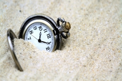 Pocketwatch partially buried in sand