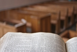 View of empty pews from pulpit with an open book (Bible) on it