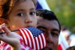 Little girl who adult holding an American flag