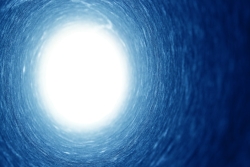 Blue circular tunnel with white light opening at the end