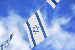 String of Israeli flags against a blue sky 
