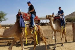 The author and his daughter riding camels in Israel
