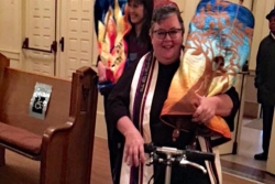The author on her scooter carrying a Torah scroll