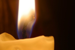 Close-up of flame of single yellow candle