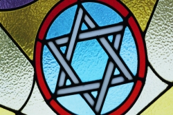 Stained glass window that includes a Jewish start in the middle
