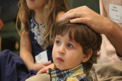Tot Shabbat attendee with his father's hand on his head for a blessing