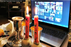 Shabbat candles next to a Zoom screen