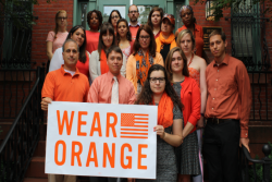 people wearing orange and holding a sign that says "wear orange"