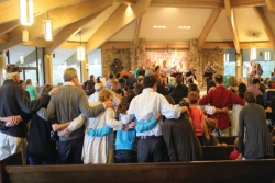 Congregants welcoming Shabbat with arms linked together