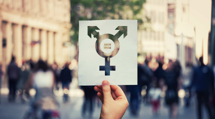 Hand holding up a sign that represents multiple genders