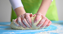 a woman kneads dough for bread