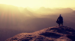 Man views a mountain sunset