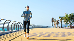 A woman runs along a fence