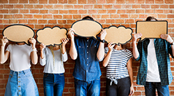 A group of people cover their faces with blank thought bubbles