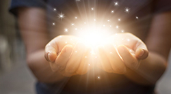 A woman holds out her hands seemingly holding rays of light