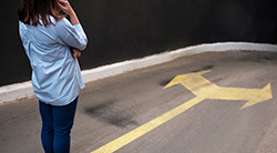 Young woman looks at two directions in the road