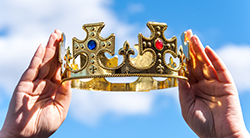 Hands lift up a king's crown