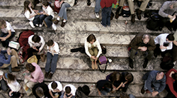 A woman sits alone in a crowd