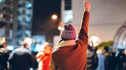a woman raises her arm in protest
