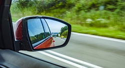 view of the road from a car's side-view mirror