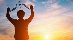 A man raises his hands showing a broken chain