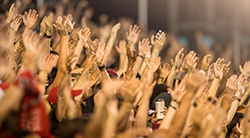 A crowd of people raising their hands