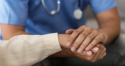 a doctor holds a patient's hand