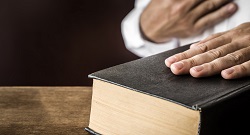 Hand resting on a  bible