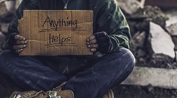 a man hold a sign asking for help