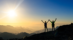 Hikers reach up toward the sky