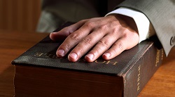 a hand rests on a Bible