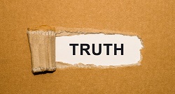 a torn paper reveals the word, truth, written underneath it