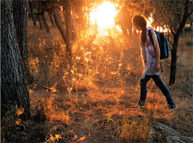 woman walking into woods