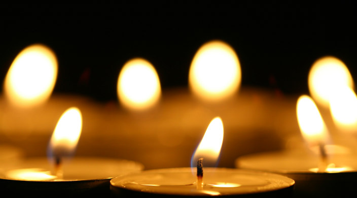 A row of lit votive candles